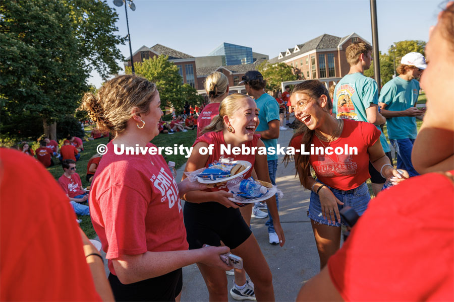 Marcy Smith of Ft. Lauderdale, Florida, center, shares a laugh with Mara Gleeson of St. Paul, Minnesota, and Carmella Chavez of Omaha. Chancellor’s BBQ in the green space between the Nebraska Union and Kauffmann Academic Residence Center. August 18, 2023. Photo by Matthew Strasburger / University Communication.