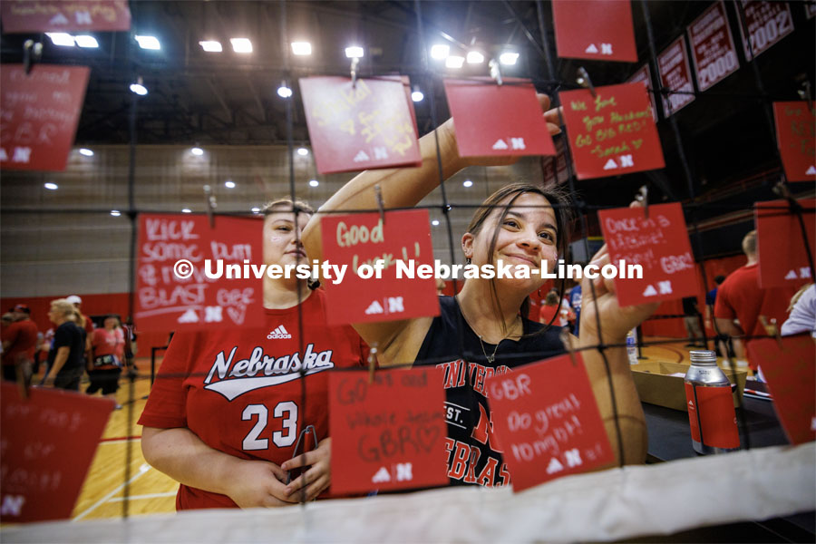 Sarah Argarin, a junior from Los Angeles, clips on a good luck note to a net set up at the Rally at the Coliseum. Volleyball Day in Nebraska. Husker Nation stole the show on Volleyball Day in Nebraska. The announced crowd of 92,003 surpassed the previous world record crowd for a women’s sporting event of 91,648 fans at a 2022 soccer match between Barcelona and Wolfsburg. Nebraska also drew the largest crowd in the 100-year history of Memorial Stadium for Wednesday’s match. August 30, 2023. Photo by Craig Chandler / University Communication.