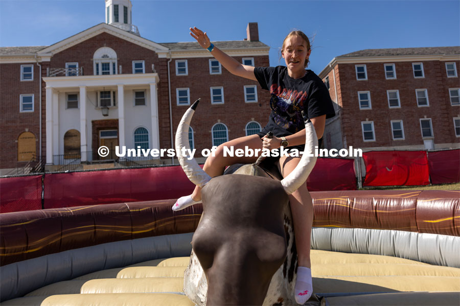 Meghan McDonald holds on to mechanical bull at Hanging with the Huskers event September 29, 2023. September 29, 2023. Photo by Dillon Galloway for University Communications.