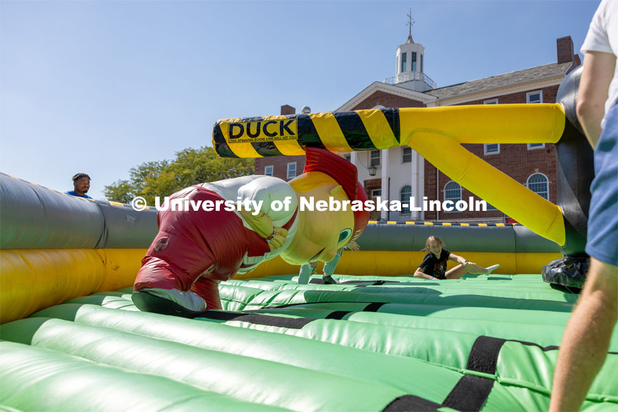 Lil Red' ducks under spinning inflatable at Hanging with the Huskers event. September 29, 2023. Photo by Dillon Galloway for University Communications.