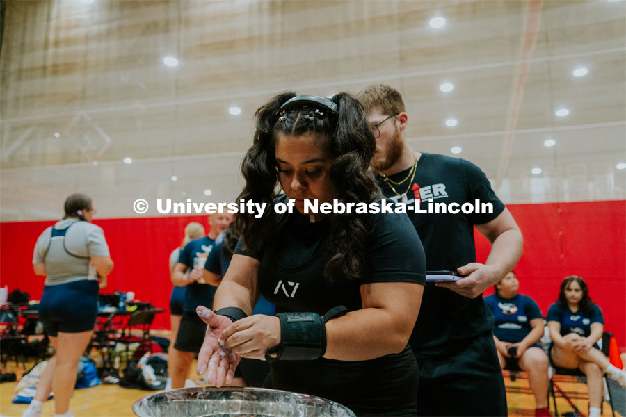 Jenny Hernandez, senior nursing student, applying chalk to her hands during the Strong Husker Powerlifting meet hosted by UNL Barbell Club held in the Coliseum. October 7, 2023. Photo by Jonah Tran / University Communication