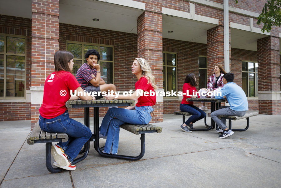 Raikes students hang out at the tables outside of the Kauffman Academic Residential Center. Raikes School photo shoot. October 18, 2023. Photo by Craig Chandler / University Communication.