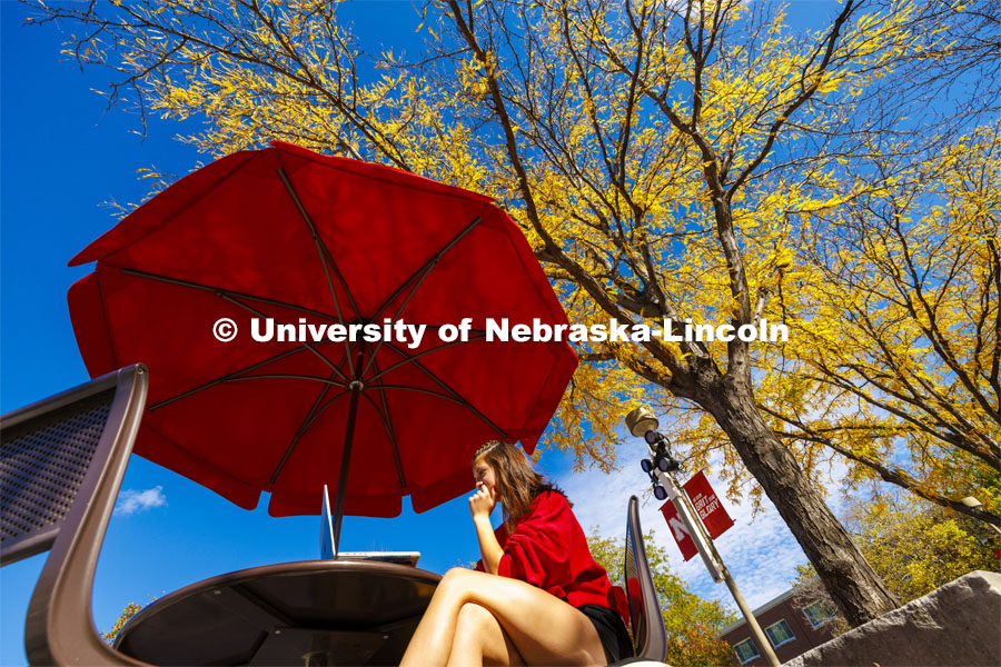 Camille Andelt from Crete, Nebraska, studies on the Union Plaza on one of the last warm days of fall. Fall on city campus. October 24, 2023. Photo by Craig Chandler / University Communication.
