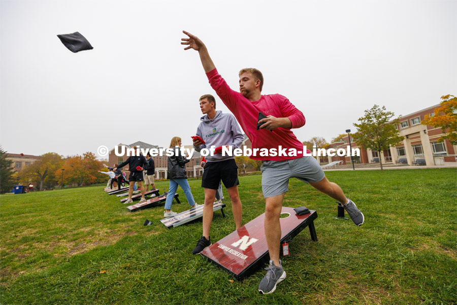 Brayan Van Meter throws a bag as he competes for Phi Delta Theta. Cornhole Tournament for Homecoming in the greenspace by the Nebraska Union. October 25, 2023. Photo by Craig Chandler / University Communication.