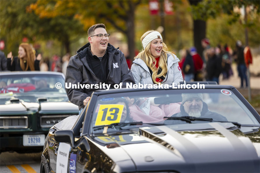 Homecoming royalty candidates Dylan Anderson and Madison Stracke wave to the crowd along the parade route. Homecoming parade and Cornstock. October 27, 2023. Photo by Craig Chandler / University Communication.