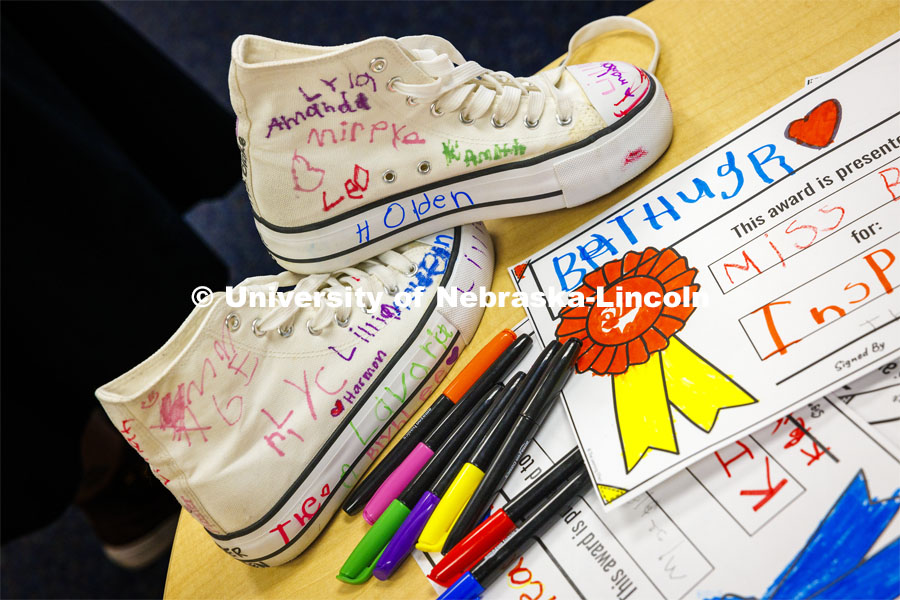 Crandall Blake’s signed and decorated high tops sit on a table next to awards done for her by each student in her kindergarten class at Lakeview Elementary. The award at right is for Blake being the best hugger. She had her students sign a pair of white high-top shoes which she will wear at commencement so “her entire class can walk across stage with her”. December 13, 2023. Photo by Craig Chandler / University Communication and Marketing.