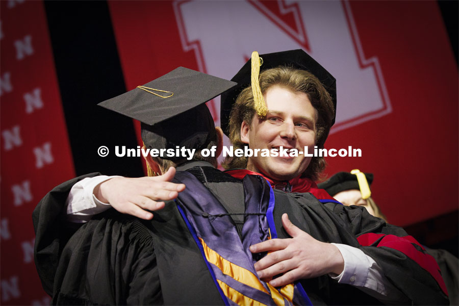 Andrew Loken, hugs Professor Joshua Steelman after Lokens received his doctoral degree in civil engineering. Graduate Commencement at Pinnacle Bank Arena. December 15, 2023. Photo by Craig Chandler / University Communication and Marketing.