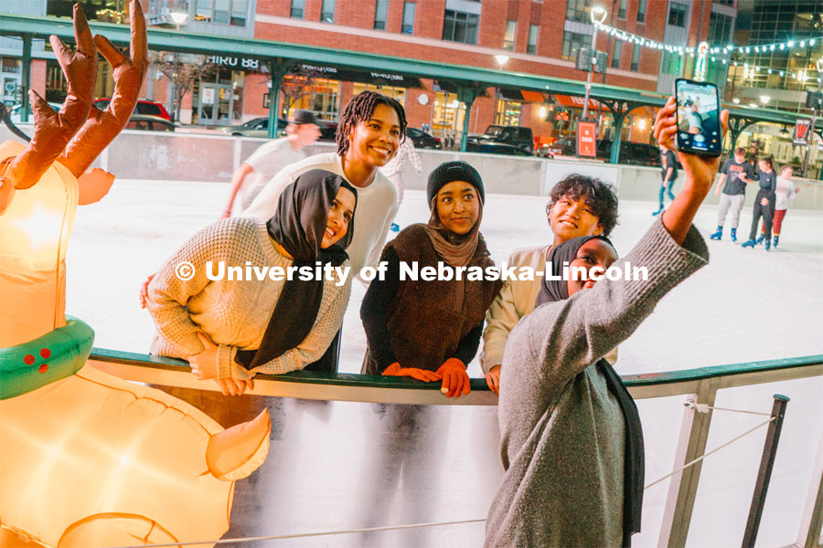 Students stop for a selfie at the Railyard Rink. Ice skating in the Haymarket. Photos for About Lincoln website. For About Lincoln website. December 12, 2023. Photo by Matthew Strasburger / University Communication.