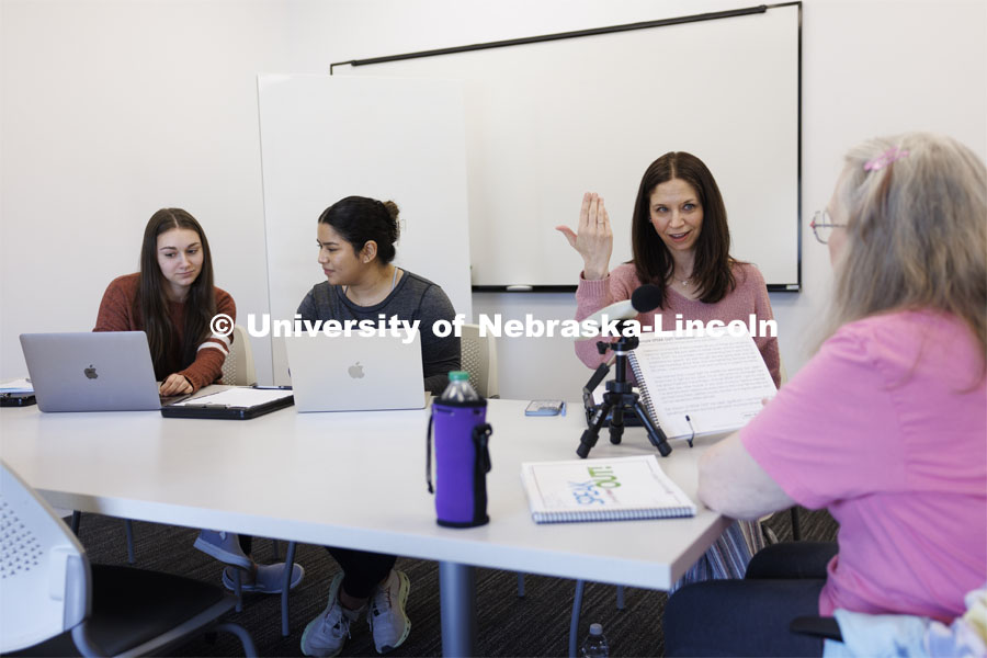 Jessie Kohn (second from right), Lecturer in Special Education and Communication Disorders, gives instructions to Rhonda Heiserman (far right) of Lincoln, during her clinic session. The instrument on the table measures the decibel level of Heiserman’s speech. Graduate students Claire Streeter, left, and Nayeli Cruz takes notes. Parkinson Voice Project. February 6, 2024. Photo by Craig Chandler / University Communication and Marketing.