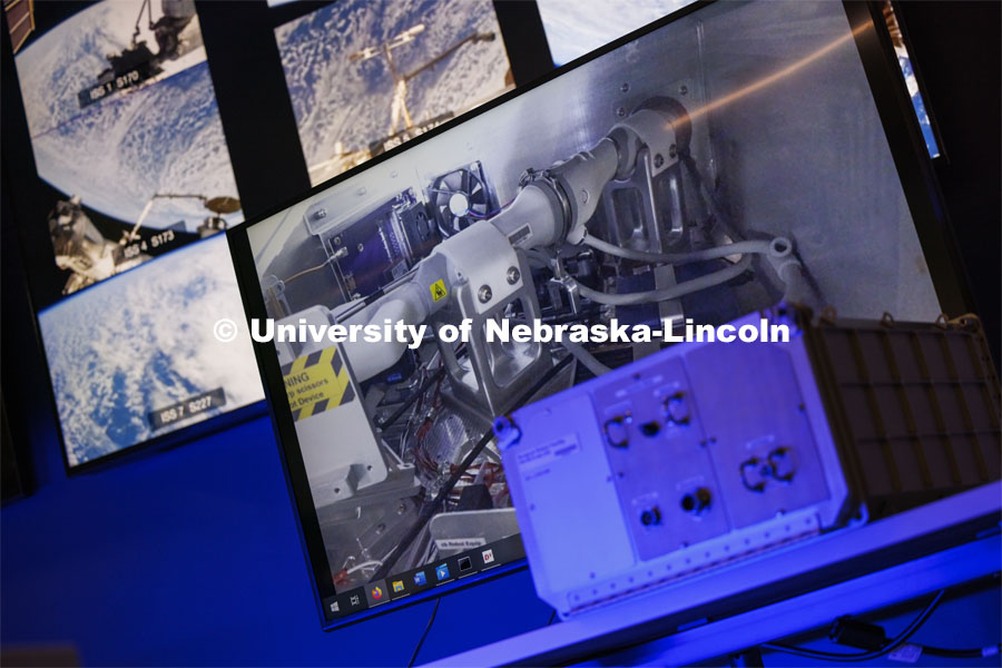 A duplicate of the box holding a Space MIRA sits on a table in front of screens showing the video feed from the International Space Station. Nebraska Engineering professor and Virtual Incision founder Shane Farritor successfully performed robotic surgery on the International Space Station. Controlled from the Virtual Incision offices in Lincoln, NE, surgeons cut rubber bands–mimicking surgery–inside a payload box on the International Space Station. February 10, 2024. Photo by Craig Chandler / University Communication and Marketing.