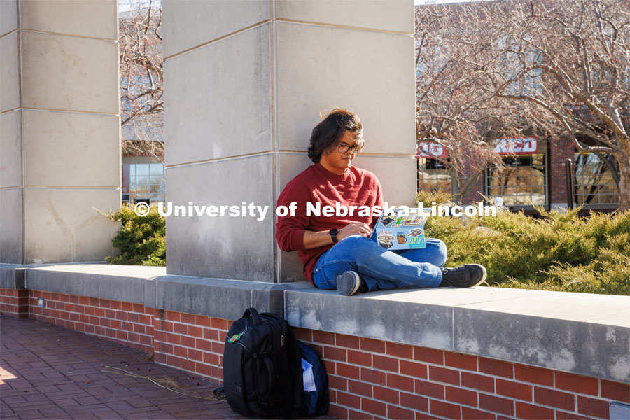 Hendy Ginting does homework outside of the Union on City Campus. February 20, 2024. Photo by Kristen Labadie / University Communication.