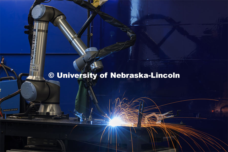 A robotic welder works its way around a metal sculpture welding in spots programmed into its computer. Nebraska Innovation Studio is working with robotic arms and teaching students and local industry people how to use them. February 20, 2024. Photo by Craig Chandler / University Communication and Marketing.