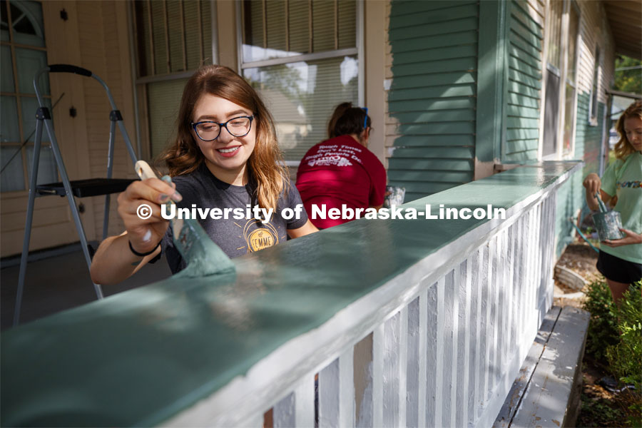 190824_Law_Paint_005.jpg Deena Keilany of Omaha paints the porch rail of a home at 30th and Vine. First year law students, fa