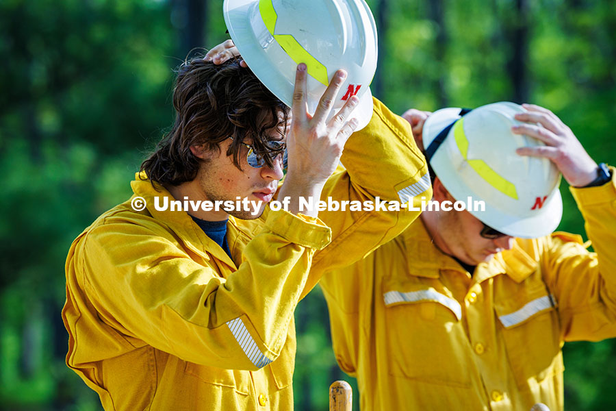 250507_Red Card Training_063.jpg Ben Beiermann, a senior Fisheries and Wildlife major, puts on his hard hat in preparation to dig a f