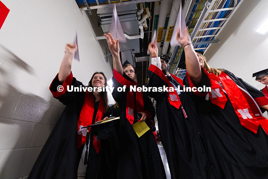 250517_Commencement_7704.jpg Charlotte Brockman (right) turned to Marcus Cureton (second from right) with a handful of her former
