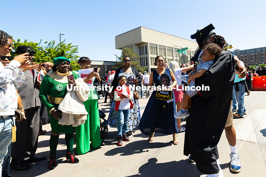 250517_Commencement_8181.jpg Family members of College of Business graduate Je'Cory Harris hold signs and take photos as he poses