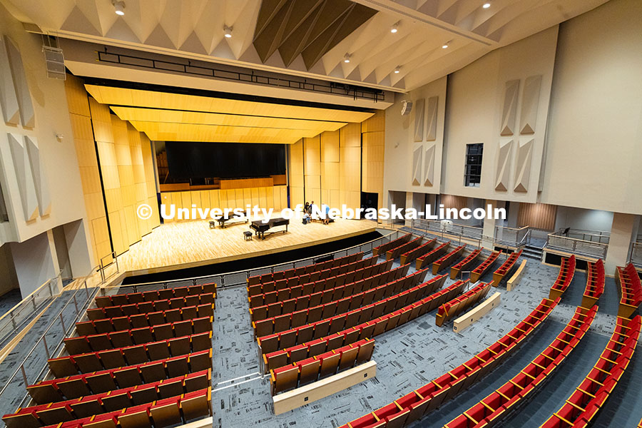 Glenn Korff School of Music students and staff move a harpsichord onto the stage of the newly renova