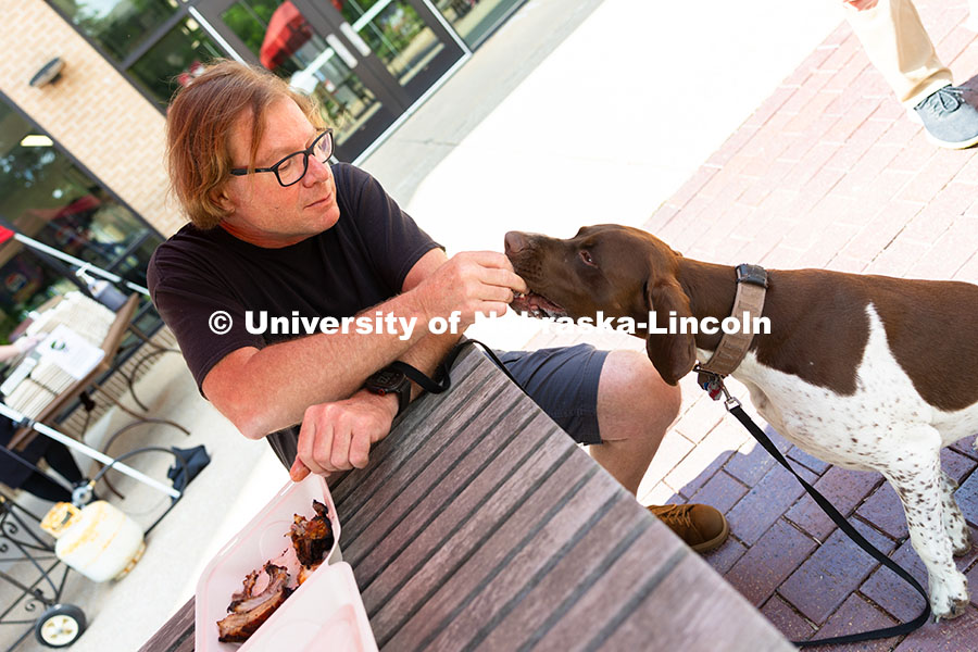 Andy Agena gives Gaspard, a French pointer, a taste of his smoked ribs at the first of East Campus D