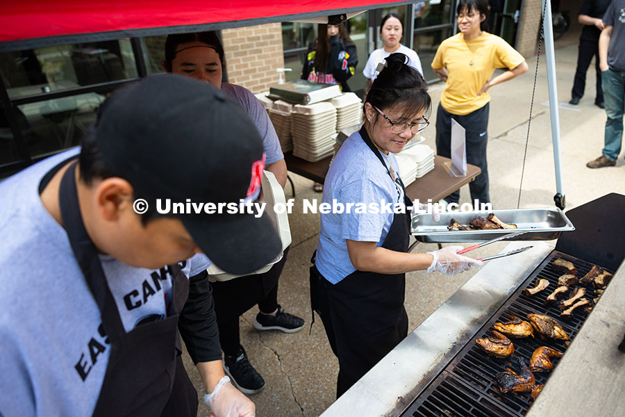 250529_Grill_Out_9376.jpg Marilou Wyatt, East Campus Dining Services production manager, uses tongs to put pork ribs on the gr