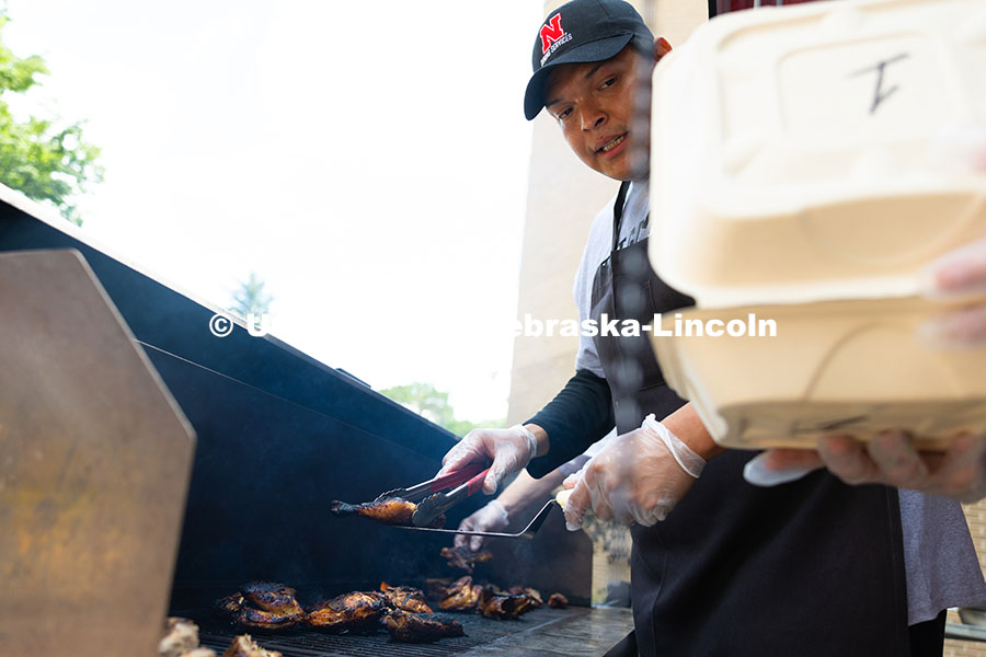 250529_Grill_Out_9400.jpg Franklin Yankton holds a piece of chicken steady on a spatula as he moves it from the grill to a to-
