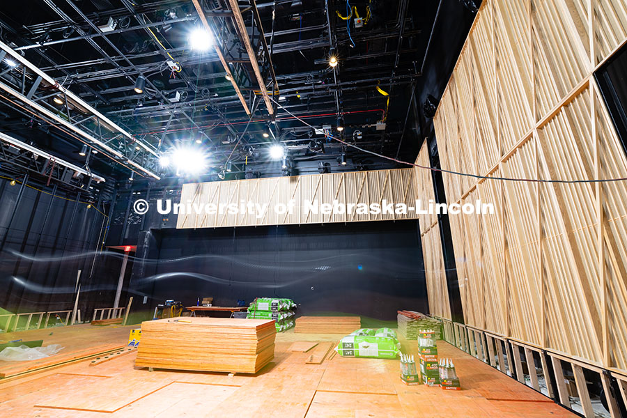 250716_FPA_2856.jpg A construction worker identifiable only by the streak of a neon green shirt and white hardhat walks