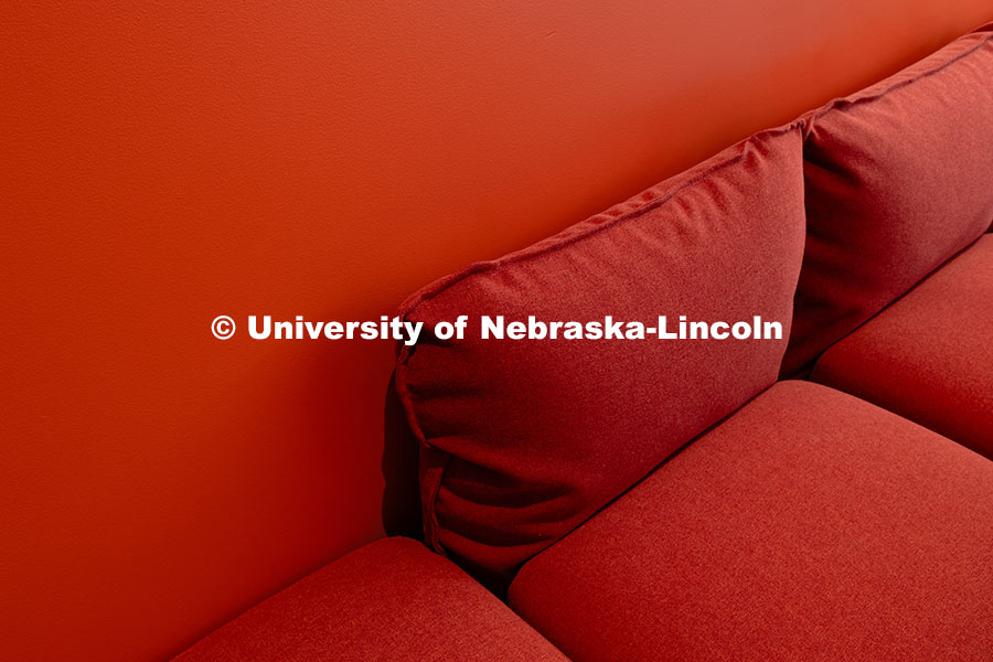 250716_FPA_2980.jpg An orange couch is situated against an orange-painted wall in a study nook on the second floor of th