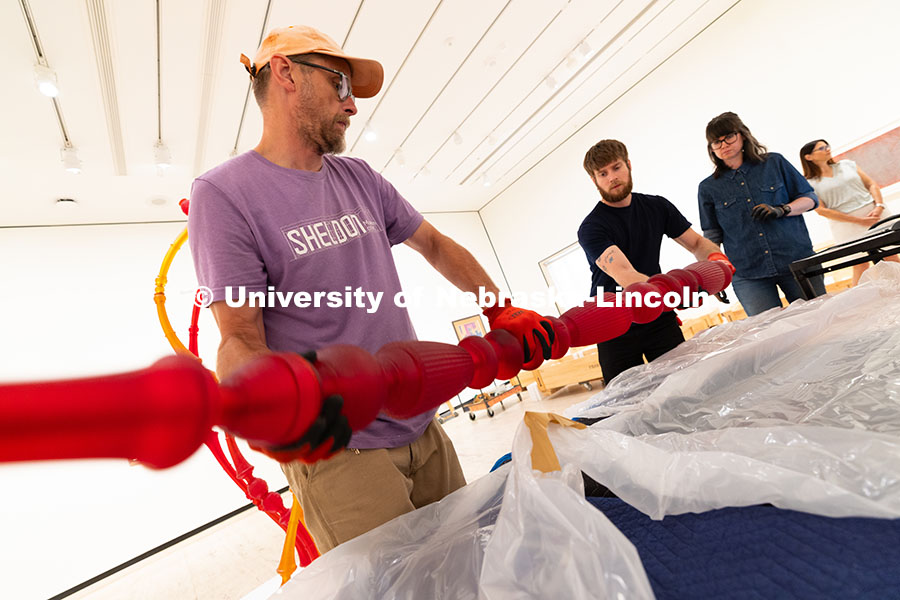 250729_Sheldon_3184.jpg Delan Lonowski (left) and Quentin Fortney (right), on-call exhibition technicians, move part of a sc