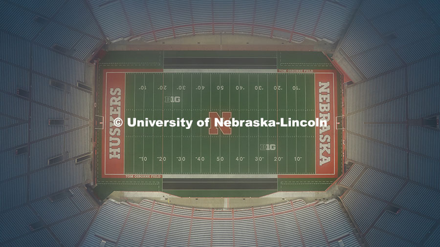 Aerial view of Memorial Stadium lights flooding Tom Osborne Field at sunrise. August 12, 2025. 