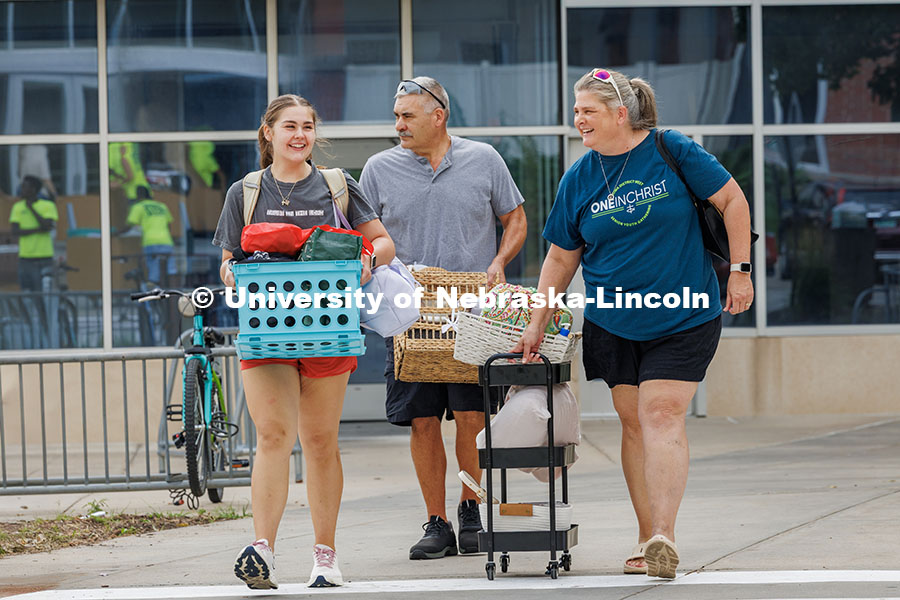 A family walk together into the Abel/Sandoz dorms for Husker Move-In. Residence hall move-in. August