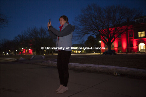 Academic Advisor Molly Brandt takes a picture with her phone during Glow Big Red. Glow Big Red bathe