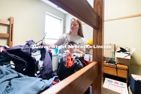 Abi Schoup hangs up clothes in her room. Abi is a freshman in the Honors program. She is originally 