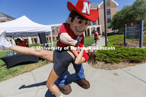 Herbie Husker dips Delanie Ferzely, a sophomore from Omaha, as they dance at the Student Tailgate an
