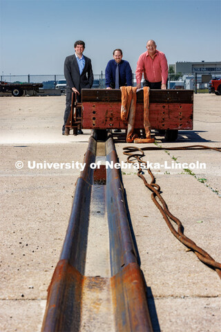 From left: Cody Stolle, Josh Steelman and Ron Faller lean against a sled connected to a ground ancho