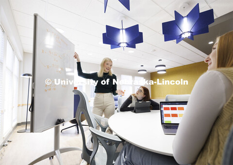 Madalyn Schoneman, works on a white board with Sarah Danahy and Alexis Tenorio in the Knoll Resident