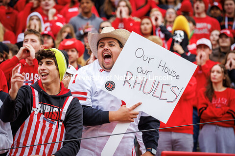 A fan cheers holding a sign saying “Our House our Rhules” at the Nebraska vs UCLA football game.