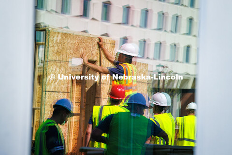 Freshman Samuel Coronado stands on a ladder and holds the wall into place of his group’s shed in t