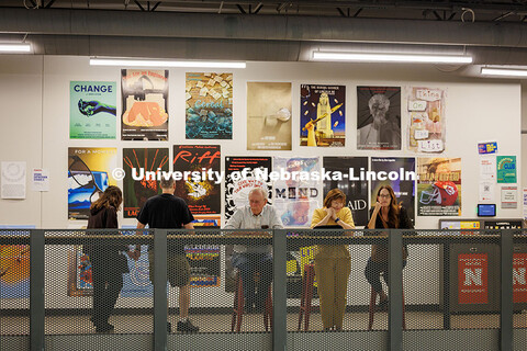 Visitors sit in front of a wall of projects from Professor, Jesse Fleming’s, Visual Expression Stu