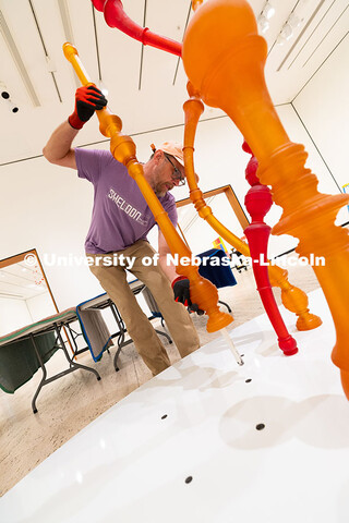 Delan Lonowski, an on-call exhibition technician for the Sheldon Museum of Art, fits one of the smal