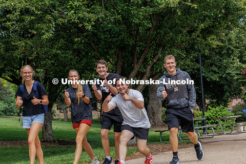 Groups of students tour campus during Big Red Welcome Week. One tour group gives a thumbs up. August