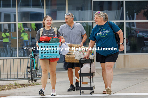 A family walk together into the Abel/Sandoz dorms for Husker Move-In. Residence hall move-in. August