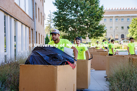 Move-in workers push boxes of items for students moving into Massengale Hall on East Campus. Residen