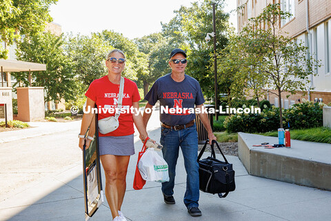 The Weese family, sporting “Husker Mom and Husker Dad” T-Shirts, carry their son’s items into 