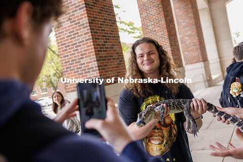 Luke Wilbur, freshman, takes a photo while holding Tripod the alligator during the Wildlife Encounte