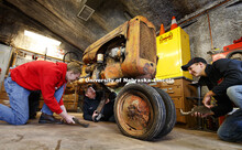 Tractor restoration club members Kiel Kruse, Joshua Bauer and Jaythan Scheideler work with support p