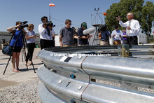 Bob Bielenberg, right, explains the new highway barrier being tested to the media and the NASCAR tou