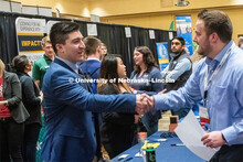 Oscar Chavez-Franco introduces himself with a recruiter from TEK systems at the STEM Career Fair (Sc