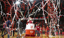 Herbie Husker pops out of a birthday cake as he and head football coach Scott Frost, Chancellor Ronn