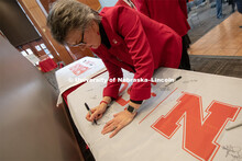 Jane Green, signs one of the four Alumni N150 flags. The flags will travel around the world to vario