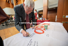 Former Chancellor, Martin Massengale signs one of the four Alumni N150 flags. The flags will travel 