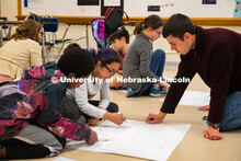 Worlds of Connections undergraduate mentor Luke Novak (right) works with a group of middle-school st